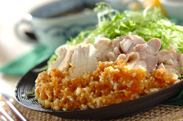 黒い皿に盛られているゆで鶏のさっぱりねぎソース