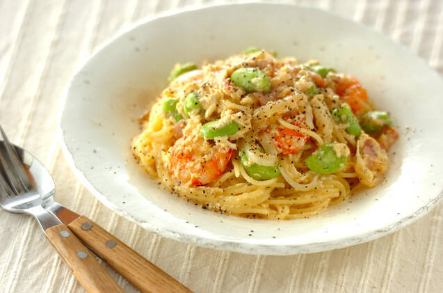 白いパスタ皿に盛ったそら豆とえびのクリームパスタ