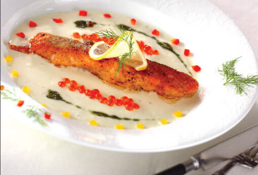 白い皿に盛り付けられたホワイトソースのサーモンムニエル