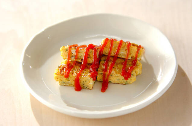 白い小皿に盛りつけられた新玉ねぎとドライパセリ入りの卵焼き