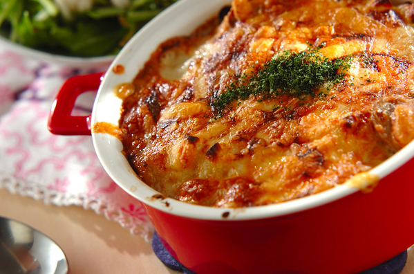 持ち手が付いた赤いグラタン皿の中のマカロニグラタン