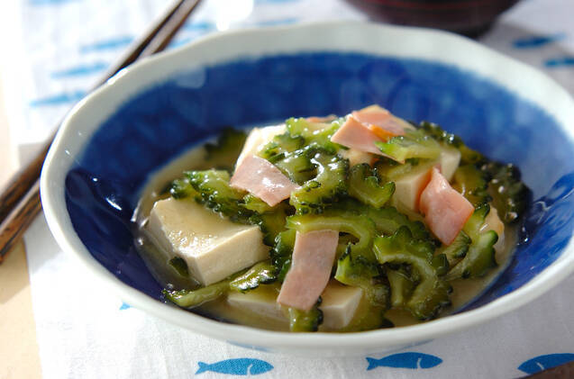 模様入りの小鉢に盛りつけられたゴーヤとハム、木綿豆腐の炒め煮