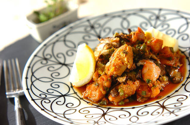 黒い線で模様の入った白い平皿に盛られた、鶏肉の風味焼き