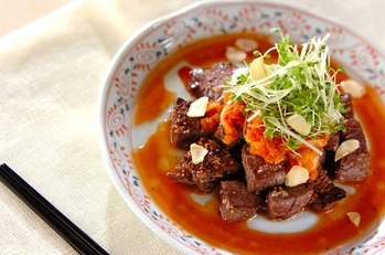 お皿に盛られたさいころすてーき中華風 上に白ネギとにんにくチップ