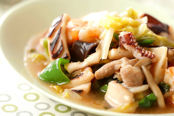 白い深皿に盛りつけられたいかといろんな野菜、えびの中華炒め