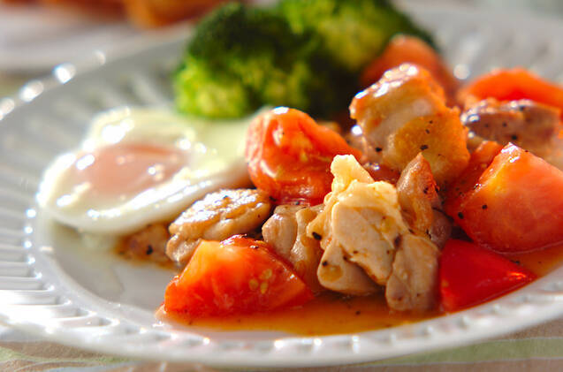 白い丸皿に盛り付けられた鶏肉とトマトの黒こしょう炒め・目玉焼き・ブロッコリー