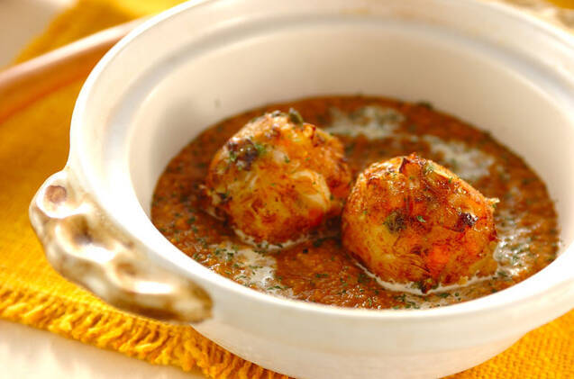 取っ手付きの白い小鍋に盛りつけられた野菜の揚げ団子入り豆カレー