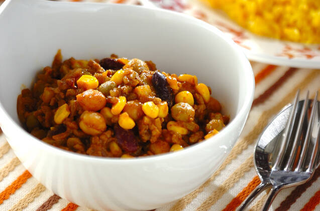 白いボウルに盛りつけられたコーンとミックスビーンズのドライカレー