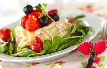 白いお皿にイチゴやブルーベリーがのせられたサラダパスタが盛られている