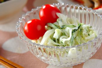 ガラスの器に盛られた白菜のコールスローの上にプチトマトが2個乗っている