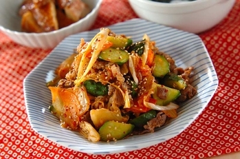 青いお皿に乗った牛肉ときゅうり漬けの炒め物