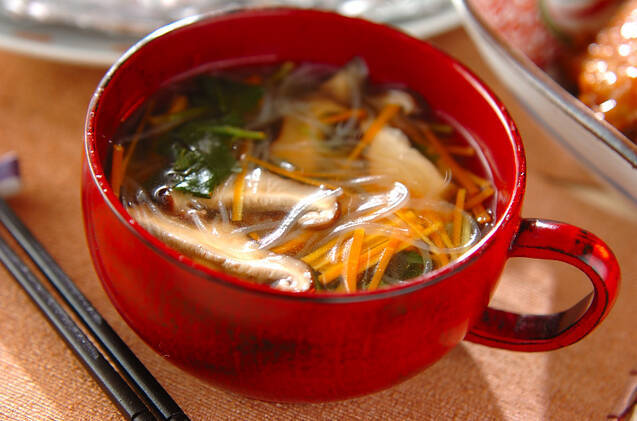 赤いスープカップに盛られた野菜ときのこの春雨スープ