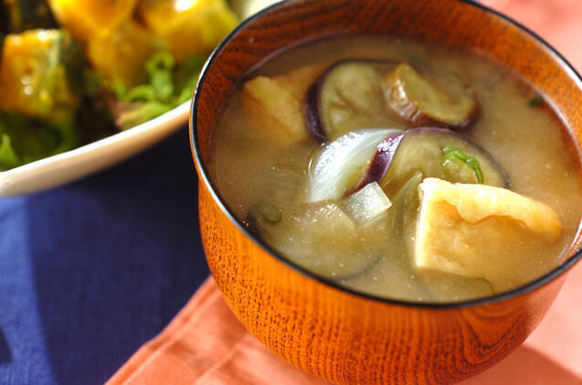 木のお椀に盛りつけられたなすと玉ねぎ入りのみそ汁
