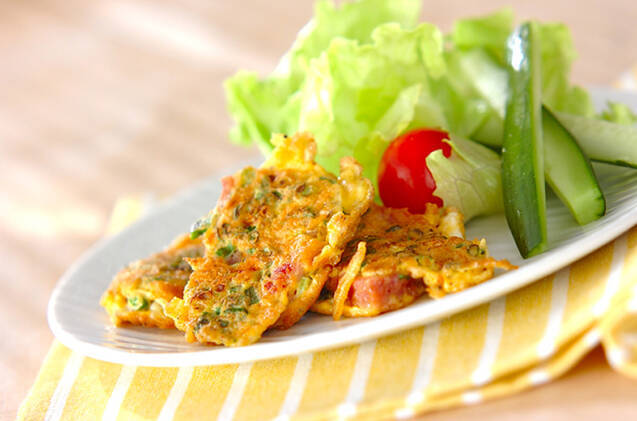 白い丸皿に盛り付けたコンビーフとトマトのピカタとレタスとミニトマトときゅうり