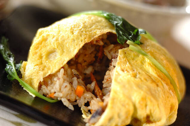 黒い皿に盛られたさんま缶の卵包みチャーハン