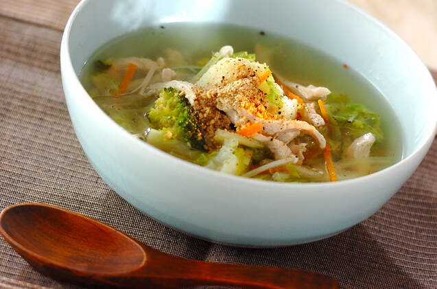 白いボウルに入っている鶏むね肉とにんじん、白菜などのスープ