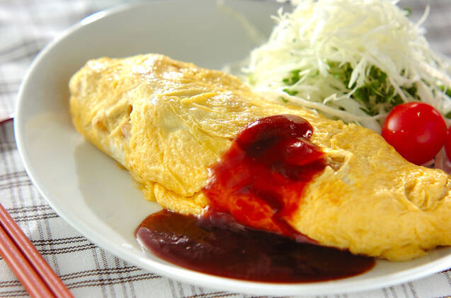 白い皿に付け合わせの野菜と盛られた、鶏肉とじゃがいものオムレツ