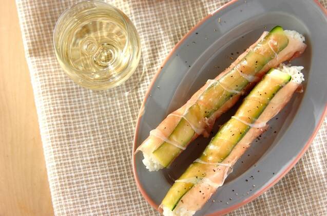 グレーの皿に盛りつけられた生ハムとズッキーニのスティックおにぎり