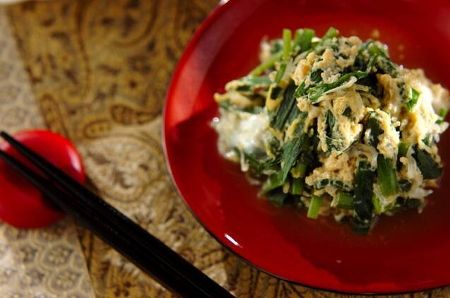 赤い皿に盛り付けたニラとしらすの卵とじ