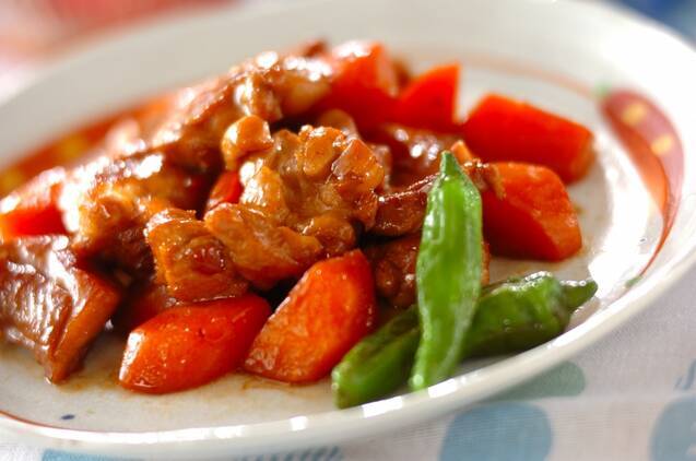 白い皿に盛られている鶏もも肉とにんじんのさっぱり煮