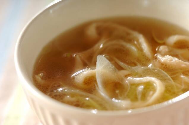 白い椀に盛り付けられた鶏皮と白ねぎのスープ