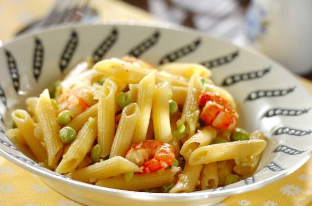 さやえんどうの絵が描かれた白色の皿に盛りつけられたグリンピースのペンネ