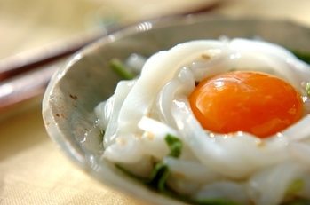 グレーの小鉢に盛られたイカと中央に黄味がのっている。