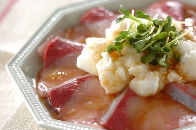 グレーの皿に盛ったぶりとたたいた長芋