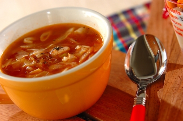 オレンジの器に盛り付けられた、鶏もも肉とキャベツのトマトスープ