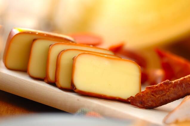 ベージュ色の皿に切り分けられたブロックチーズの燻製