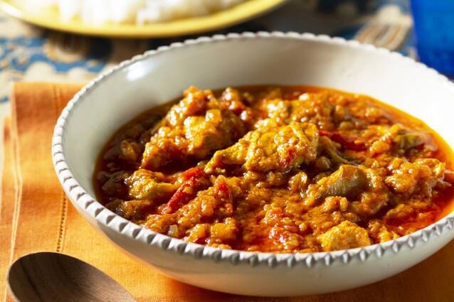 ごはんを別皿に添え、白い器に盛られたスパイスチキンカレー