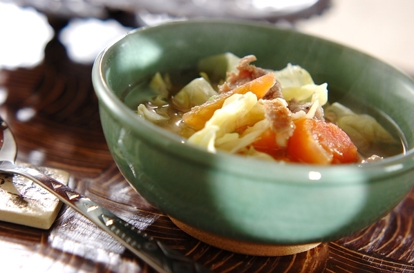 緑の皿に盛られたトマトとキャベツのエスニックスープ