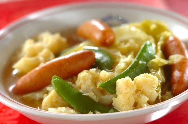 ウインナーソーセージやカリフラワーなどが入ったたっぷり野菜のカレー風味ポトフが丸い器に入っている