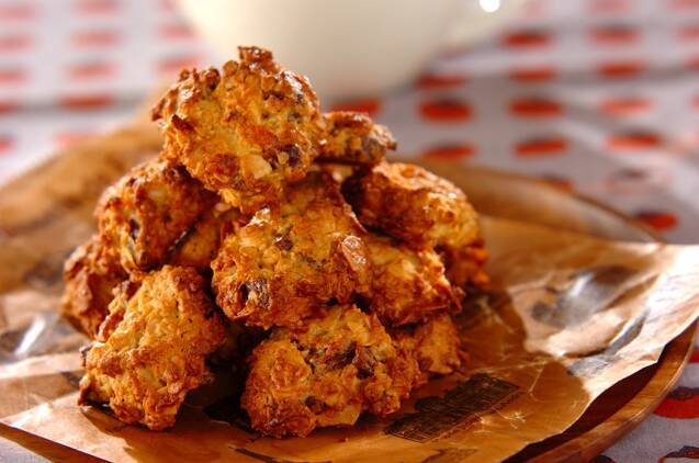 茶色いクッキングシートの上にのった干し柿のオートミールクッキー