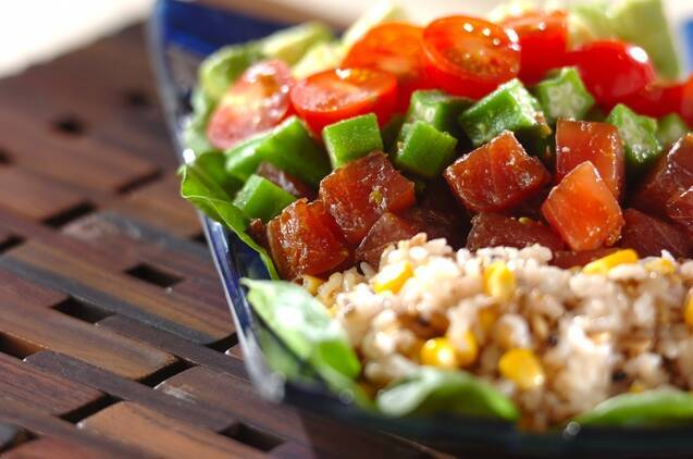 黒いお皿に盛られた、ポキ入りライスサラダ