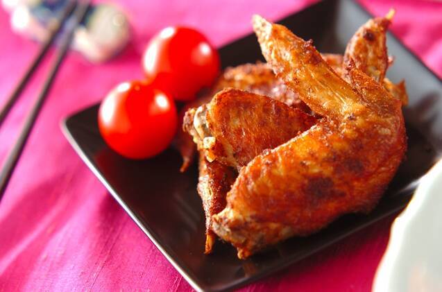 黒い皿に盛られた手羽先のカレー揚げ