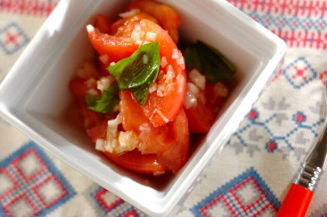 白く四角い皿に盛られたトマトとバジルと玉ねぎのマリネ