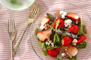 ガラスの丸い器にイチゴがたくさん入ったサラダが盛られている