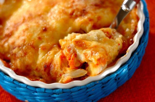 耐熱皿に入ったキムチのチーズ豆乳グラタンをスプーンですくっている様子