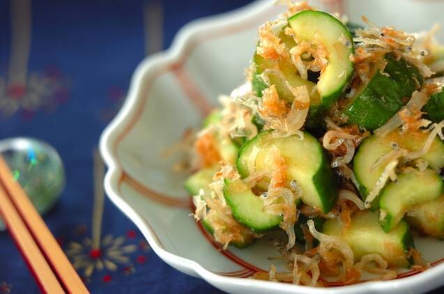 テーブルの上、白い器に盛られたきゅうりとちりめんじゃこのソテー