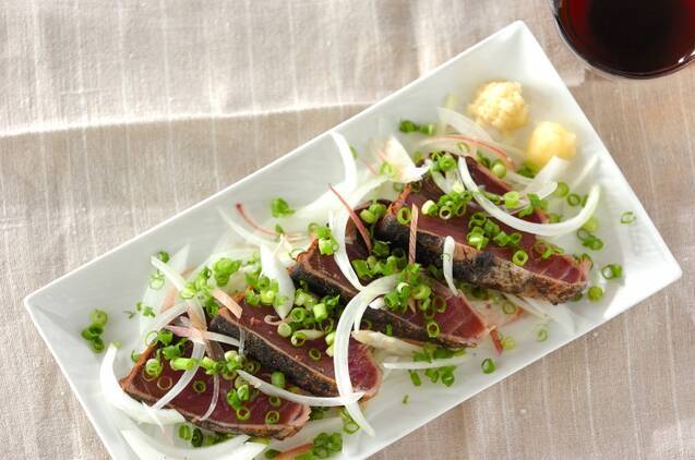 白い長皿に盛り付けられたかつおのたたき