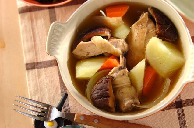 ベージュ色の鍋に大根と鶏肉のコンソメ煮が盛られている様子