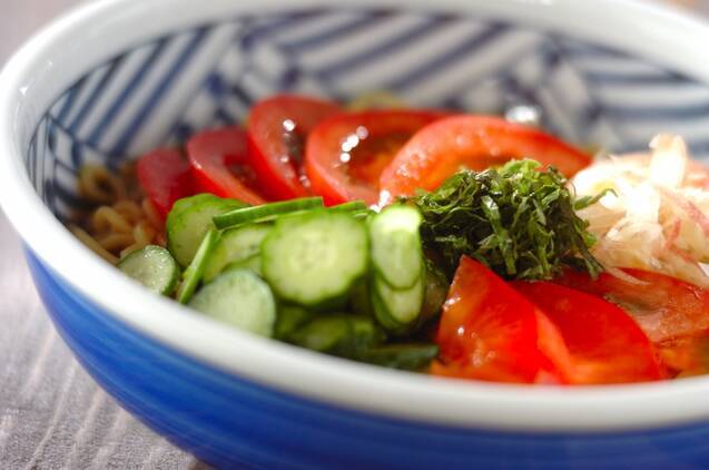 青い柄の椀に盛り付けられたトマトとみょうがの冷やし中華