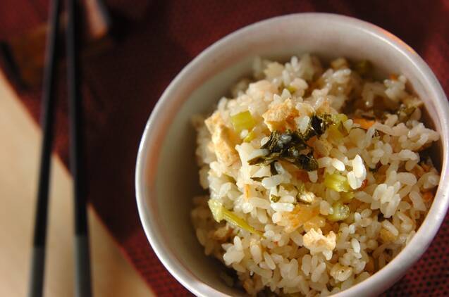 白い茶碗に盛りつけられた大根葉と油揚げ入りの炊き込みごはん