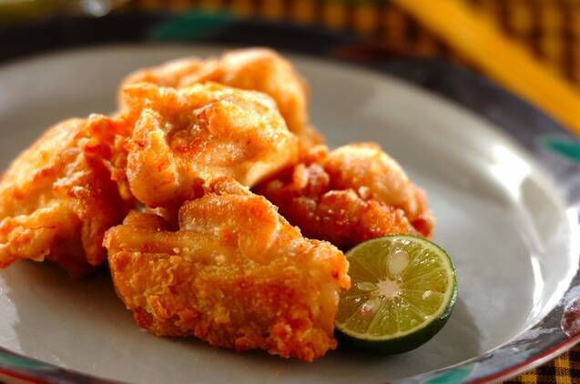 白い皿に盛られた唐揚げとすだち