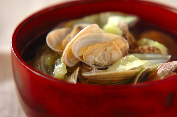 赤のお椀に入ったアサリとキャベツの和風スープ