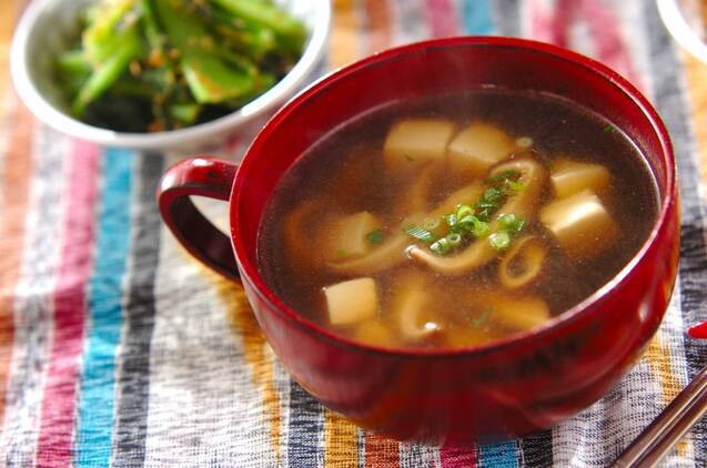 赤いスープ皿に盛られた豆腐と干し椎茸のスープ