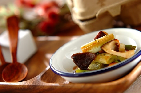 青い縁の白い皿に盛り付けられている長ねぎとしいたけのしょうゆマリネ