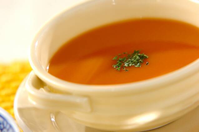 白いカップに盛りつけられているえび風味のトマトスープ