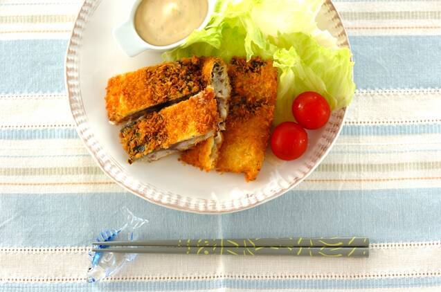 平たい皿に盛り付けたしめ鯖フライ、ミニトマト、レタス、ソースと青のクロス、緑のお箸